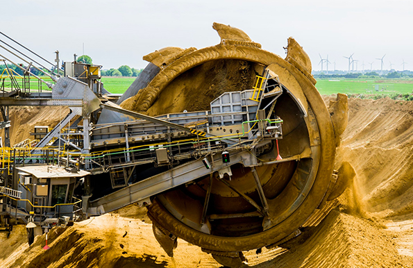 Round brown and gray metal heavy equipment on sand