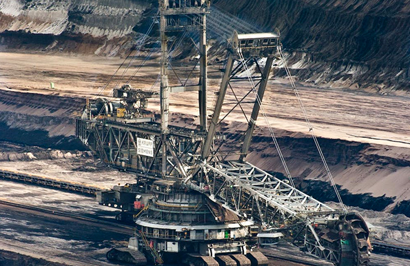 Silver steel mining crane on black rocky soil during daytime